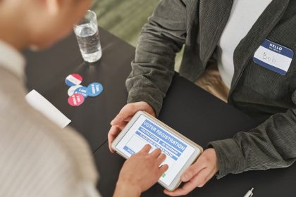 Pessoa utiliza um tablet em uma estação eleitoral.